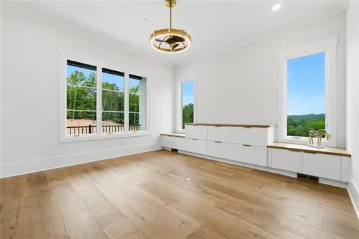 Bright unfurnished room with windows and wood flooring